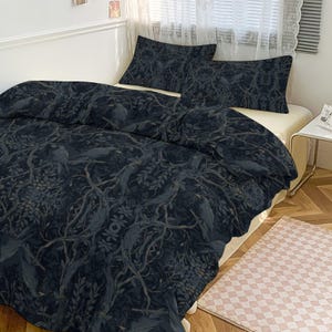 May include: Dark blue bedding set featuring a detailed pattern of trees and birds. The set includes a duvet cover and two pillowcases. The design has a vintage aesthetic, with a focus on natural elements and a muted color palette.