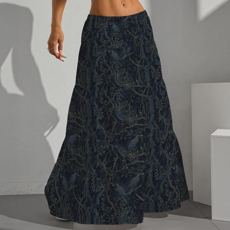 May include: A floor-length maxi skirt in a dark navy blue hue, featuring an intricate all-over print of silhouetted birds perched within dense, tangled tree branches and foliage. The skirt has a high-waisted fit and a flowing, A-line silhouette.