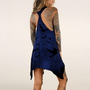 May include: A dark blue racerback tank top featuring a printed pattern of black birds in flight. The garment has an asymmetrical hemline with pointed sides and a sleeveless design, showcasing a deep navy hue with a subtle mottled texture throughout.