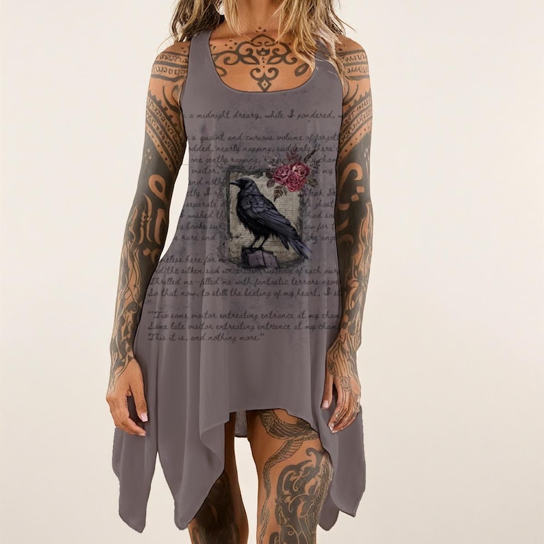 May include: A sleeveless grey tank dress featuring a printed graphic of a black raven perched on a book, accented by red roses. The fabric is overlaid with cursive text from Edgar Allan Poe's The Raven, including the phrase, This it is, and nothing more.