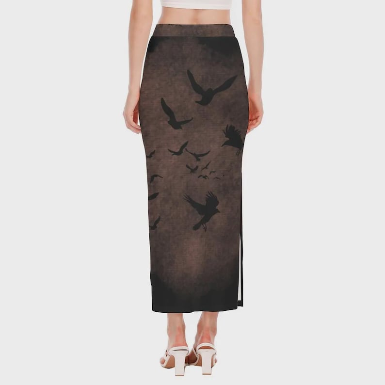May include: A long, dark brown skirt featuring a flock of black birds in flight. The skirt has a high waist and a slit on the side. The birds are silhouetted against a textured background.