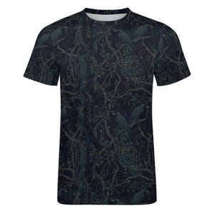 Pode incluir: Uma t-shirt de manga curta com gola redonda apresentando um padr&atilde;o escuro em toda a pe&ccedil;a de corvos pretos pousados em ramos de &aacute;rvores emaranhados e sem folhas sobre um fundo azul-marinho profundo que cobre toda a superf&iacute;cie.