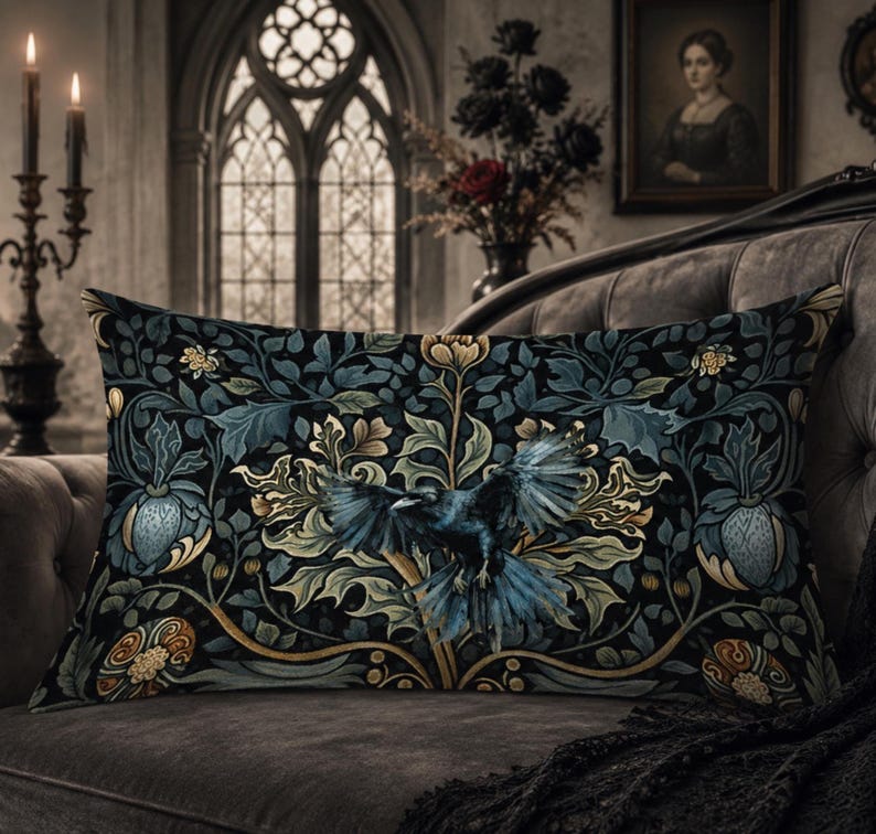 May include: A rectangular throw pillow featuring a dark, intricate botanical pattern with deep blue, green, and gold foliage. A central black crow with spread wings is depicted amidst the stylized leaves, flowers, and swirling vine motifs.