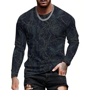 Pode incluir: Uma camisola de manga comprida com gola redonda, apresentando um padr&atilde;o de floresta escuro e sombrio com ramos de &aacute;rvore entrela&ccedil;ados e silhuetas de p&aacute;ssaros pousados na folhagem. A pe&ccedil;a tem um corte justo e &eacute; usada com cal&ccedil;as de ganga pretas.