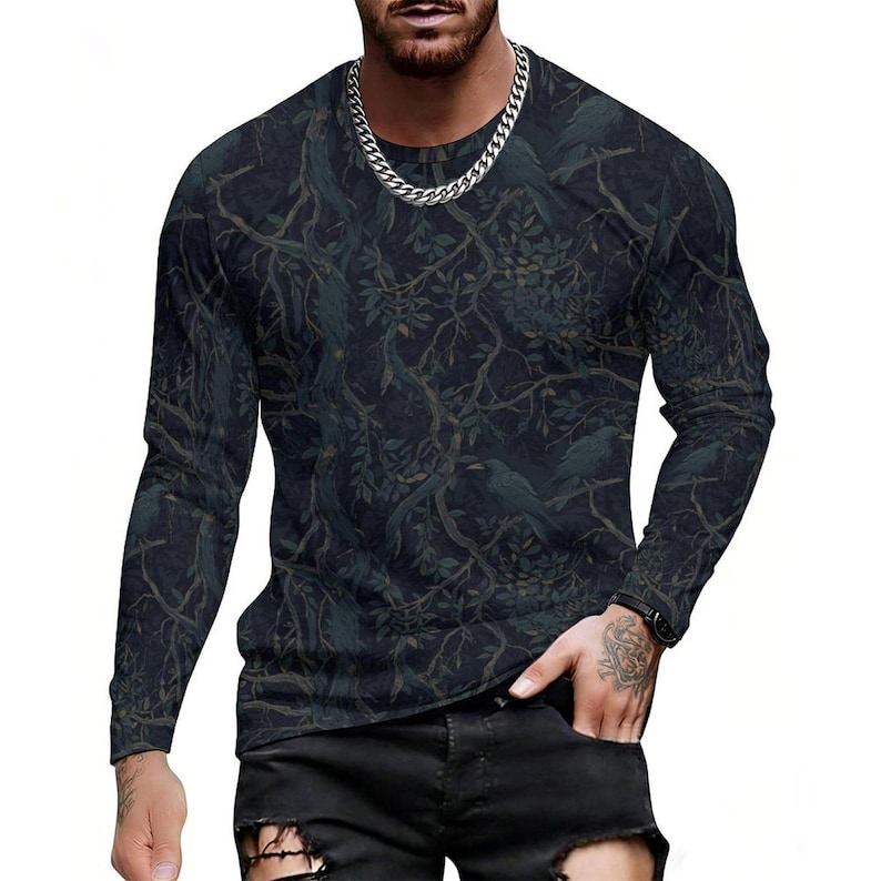 Pode incluir: Uma camisola de manga comprida com gola redonda, apresentando um padr&atilde;o de floresta escuro e sombrio com ramos de &aacute;rvore entrela&ccedil;ados e silhuetas de p&aacute;ssaros pousados na folhagem. A pe&ccedil;a tem um corte justo e &eacute; usada com cal&ccedil;as de ganga pretas.