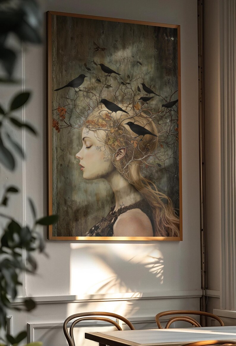 May include: A framed wall art print featuring a profile portrait of a person with long blonde hair intertwined with bare branches and autumn leaves. Several black birds are perched among the branches, set against a muted, textured background.