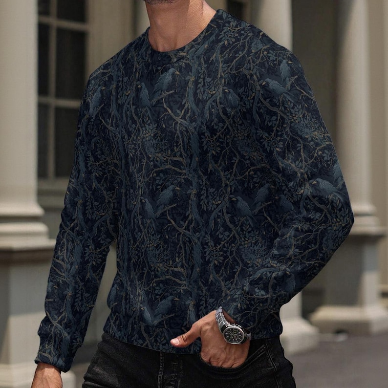 May include: A long-sleeve crew neck sweatshirt in a dark navy blue hue, featuring an intricate, repeating pattern of silhouetted birds perched within dense, tangled tree branches and foliage that covers the entire garment from neck to hem.