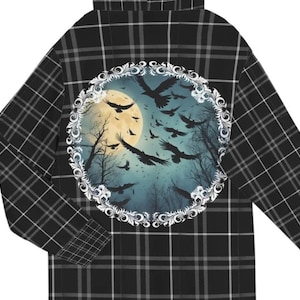 May include: Black and white plaid flannel shirt with a circular design on the back. The design features a full moon, a flock of birds, and a decorative frame.