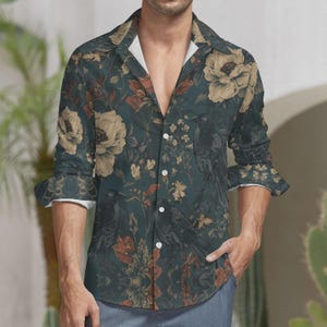 Pode incluir: Camisa abotoada verde-azulado escuro com estampa floral e de corvo. A camisa apresenta grandes flores creme, folhas vermelhas e laranja e corvos pretos. A camisa de manga comprida tem punhos brancos e gola branca.