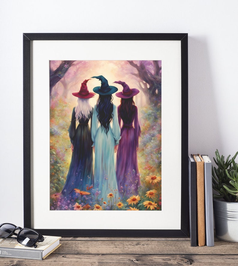 May include: A framed wall art print depicting three figures from behind, wearing long dresses and pointed hats in red, teal, and purple. They stand in a vibrant, colorful forest clearing filled with wildflowers under a soft, glowing light.