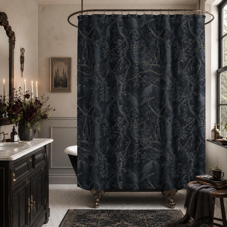 May include: A dark navy blue shower curtain featuring a repeating pattern of black birds perched on intricate tree branches with leaves. The fabric hangs from a curved metal rod with circular rings, displaying a detailed botanical and avian design.