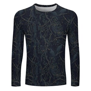 Pode incluir: Uma camisola de manga comprida com gola redonda apresentando um padr&atilde;o escuro e sombrio de corvos pretos pousados em ramos de &aacute;rvores entrela&ccedil;ados com folhagem densa. O design utiliza uma paleta de azuis profundos e tons cinza-carv&atilde;o.