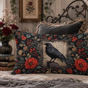 May include: A rectangular throw pillow featuring a black raven perched on a stone within a central framed parchment graphic, surrounded by a dark floral pattern of red roses and green leaves on a black background with a soft fabric texture.