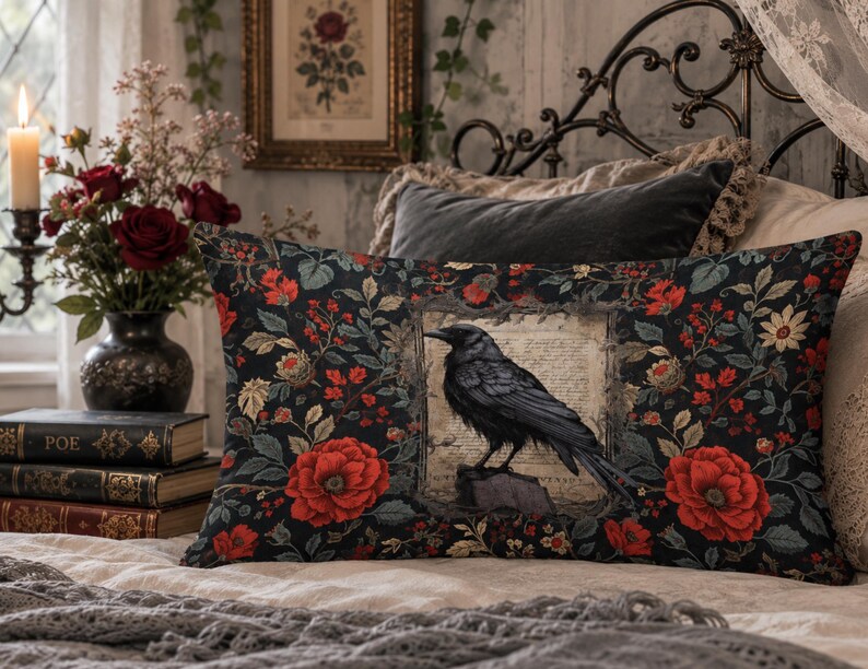 May include: A rectangular throw pillow featuring a black raven perched on a stone within a central framed parchment graphic, surrounded by a dark floral pattern of red roses and green leaves on a black background with a soft fabric texture.