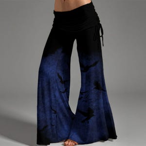 May include: Wide-leg pants featuring a high-waisted black band with side ties. The lower portion of the pants transitions into a deep blue gradient with a dark, textured pattern of silhouettes resembling flying birds across the fabric surface.