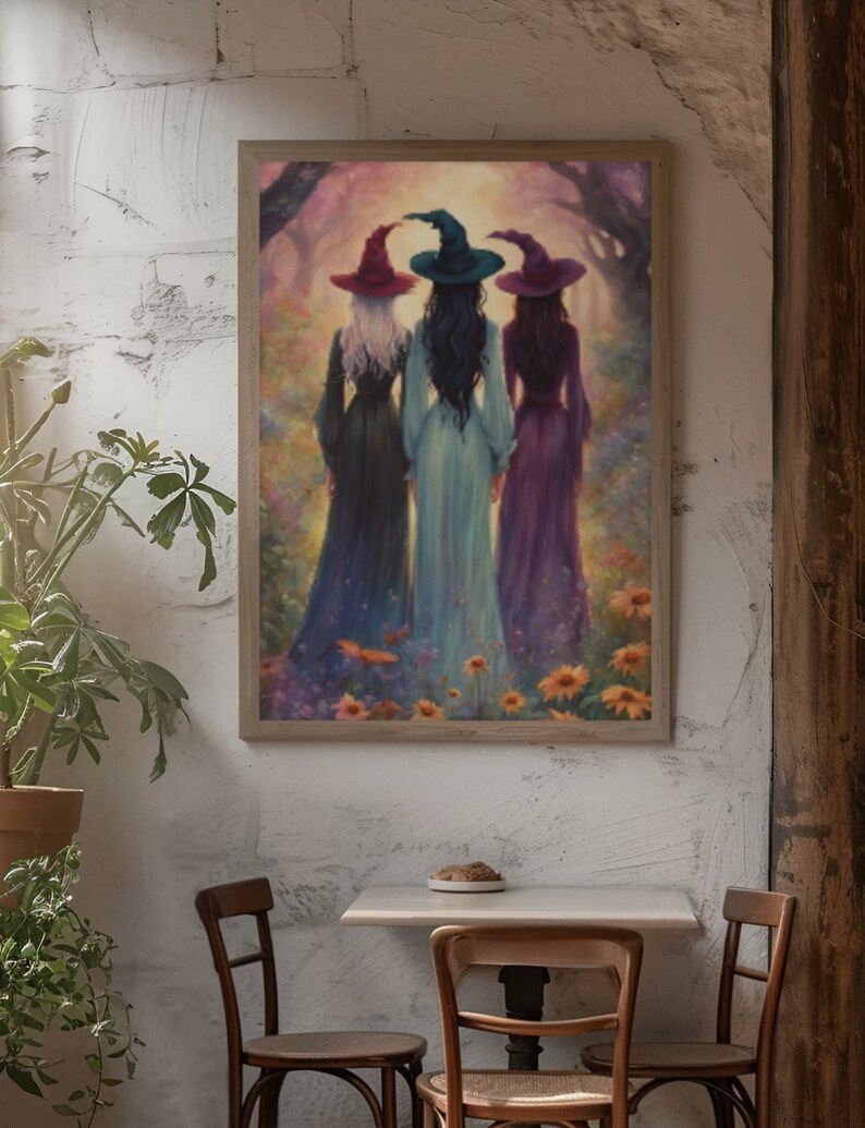May include: A framed wall art print depicting three figures standing with their backs to the viewer in a field of flowers. Each figure wears a long dress and a pointed hat in shades of red, teal, and purple, set against a soft, glowing forest.