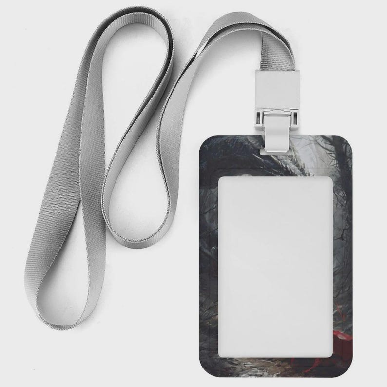 Puede incluir: Un porta credencial rectangular vertical con un cord&oacute;n de tela gris claro. El porta credencial presenta un estampado gr&aacute;fico de bosque oscuro con tonos apagados y un peque&ntilde;o acento rojo en la esquina inferior derecha, rodeando una ventana transparente.