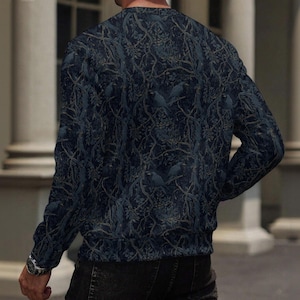 May include: A long-sleeve crew neck sweatshirt featuring a dark navy blue and charcoal gray pattern of intertwined tree branches and perched birds. The garment has a ribbed neckline and cuffs, providing a consistent fit across the torso and arms.