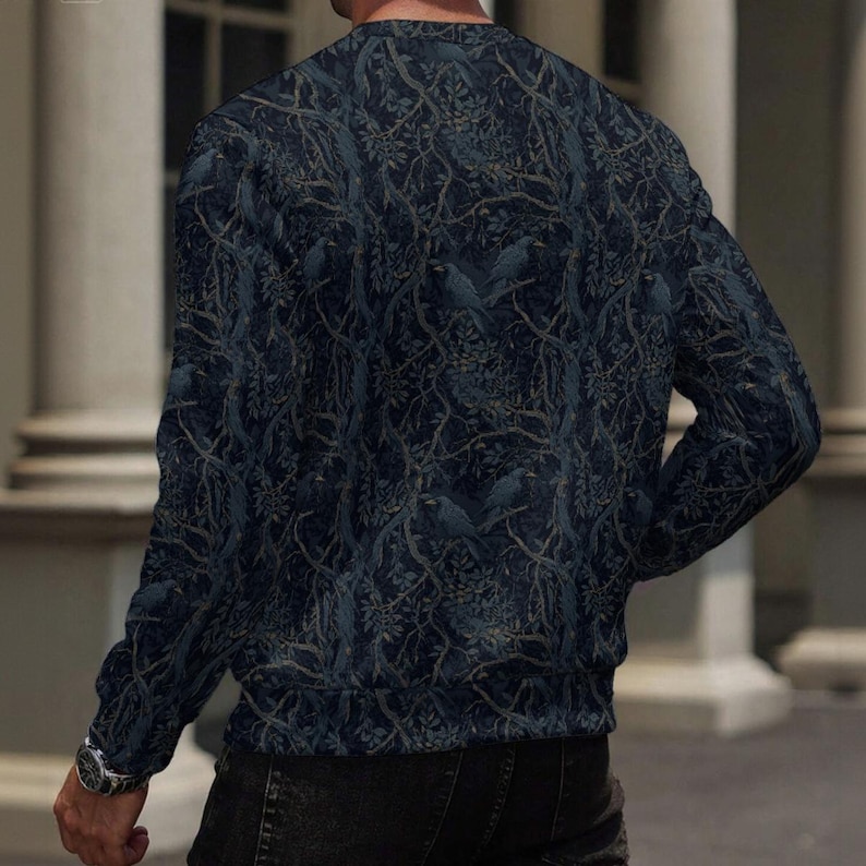 May include: A long-sleeve crew neck sweatshirt featuring a dark navy blue and charcoal gray pattern of intertwined tree branches and perched birds. The garment has a ribbed neckline and cuffs, providing a consistent fit across the torso and arms.