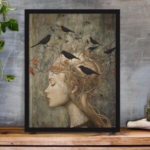 May include: A framed wall art print featuring a profile view of a person with long hair that transitions into bare tree branches. Several black birds are perched on the branches. The color palette consists of muted earth tones, beige, and black.