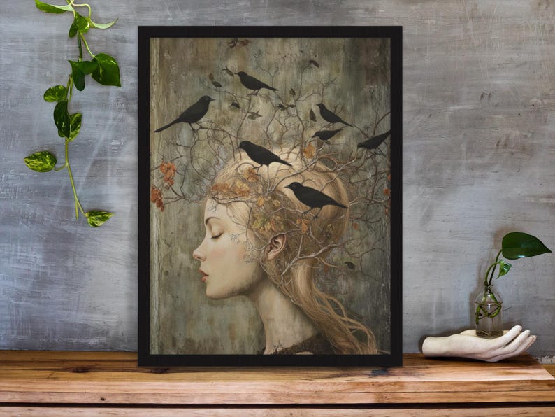 May include: A framed wall art print featuring a profile view of a person with long hair that transitions into bare tree branches. Several black birds are perched on the branches. The color palette consists of muted earth tones, beige, and black.