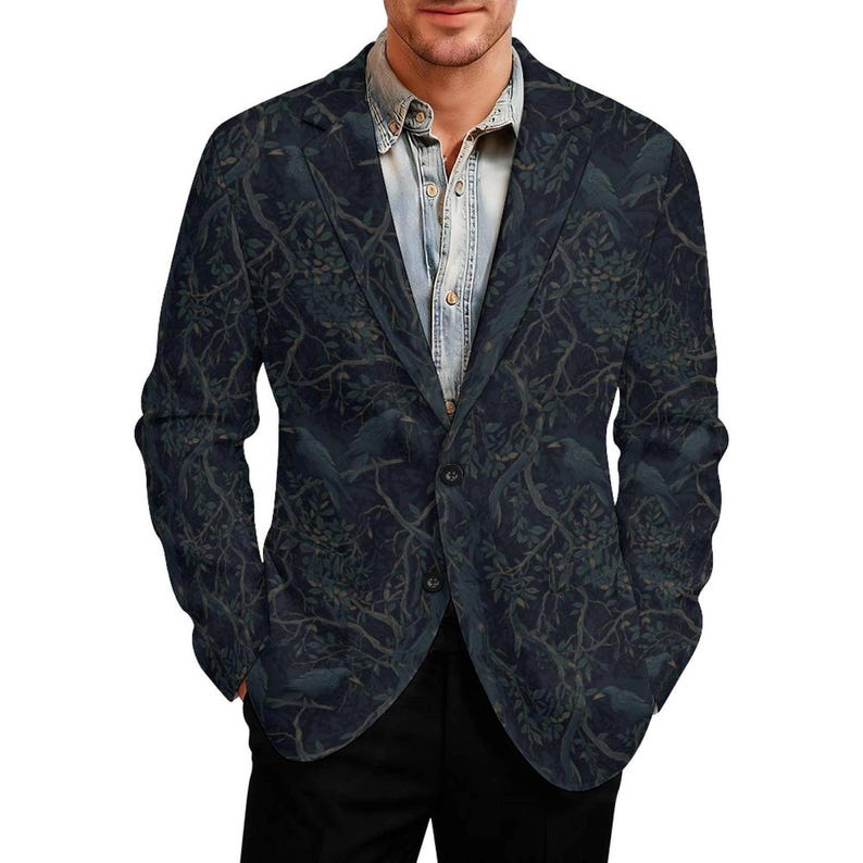 Pode incluir: Um blazer azul-marinho escuro com um padr&atilde;o repetitivo de p&aacute;ssaros pretos pousados em galhos de &aacute;rvores entrela&ccedil;ados com folhas. O blazer tem lapela entalhada, dois bot&otilde;es frontais e &eacute; usado sobre uma camisa jeans azul-clara.