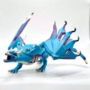 May include: A blue and purple papercraft dragon with open mouth and outstretched wings. The dragon has a geometric design with sharp angles and a detailed skeletal structure. The wings are a mix of blue and purple, and the dragon has white horns and teeth.