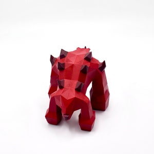 May include: Red, geometric, stylized monster figurine with black spikes. The monster has four legs and is in a crouching position.