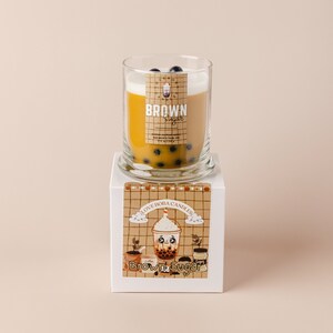 May include: A brown sugar scented candle in a glass jar with a brown sugar boba tea design. The candle is on a white box with the text "I Love Boba Candles" and "Brown Sugar" printed on it.