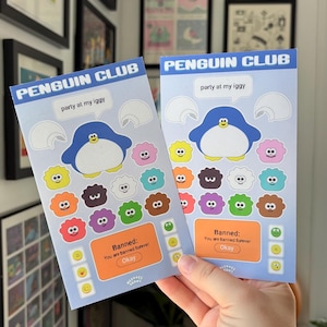 May include: Two light blue Penguin Club cards with a penguin illustration and the text "party at my iggy". The cards feature colorful cloud-like characters and the text "Banned: You are banned forever".