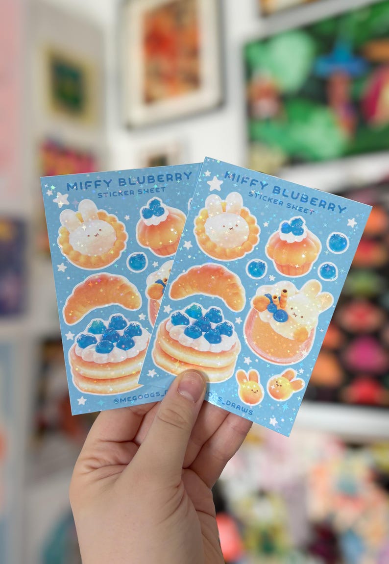 May include: Two sticker sheets with a light blue background featuring illustrations of food items and a bunny character. The text "MIFFY BLUBERRY STICKER SHEET" is printed at the top. The stickers include pancakes, croissants, and cupcakes.