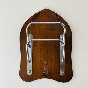 Portacorreos vintage de los años 60: soportes metálicos decorativos sobre placa de madera