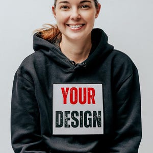 Könnte beinhalten: Ein schwarzer Hoodie mit einem weißen Rechteck auf der Vorderseite, auf dem in roten und schwarzen Buchstaben "YOUR DESIGN" steht.