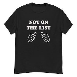 Może przedstawiać: Czarny t-shirt z białym napisem "NOT ON THE LIST" i dwiema białymi ilustracjami kciuków w górę. Koszulka ma okrągły dekolt.