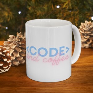 May include: White ceramic mug with the text "<CODE> and coffee" in blue and pink lettering.