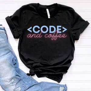 May include: Black t-shirt with the text "<CODE> and coffee" in blue and pink lettering.