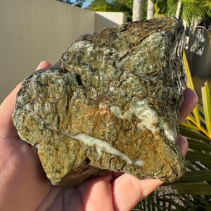 May include: A large, rough, green and white rock with a smooth, polished surface. The rock has a natural, organic look and feel.
