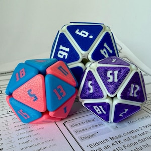 May include: Three multi-sided dice in blue, pink, and purple with white numbering, on a printed game sheet. The dice are for role-playing games. The dice are in the shape of a dodecahedron and an icosahedron.