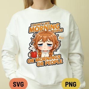 Peut inclure: Sweat-shirt blanc avec un personnage de style anime tenant une tasse rouge. Le texte orange dit : "I DON'T LIKE MORNING PEOPLE OR MORNINGS OR PEOPLE". Le personnage a des cheveux bruns et une expression fatiguée.
