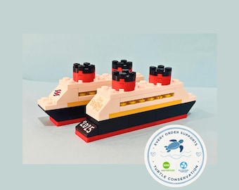 May include: Two cruise ship models constructed from plastic building blocks. The ships feature black hulls, white midsections, yellow accents, and red smokestacks. One ship displays the text Disney Destiny and 2025 on the side.