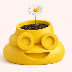 May include: A whimsical yellow planter shaped like a smiling poop emoji, with circular eye details. The planter holds soil and a daisy with white petals and a yellow center. A fun and unique decorative item.
