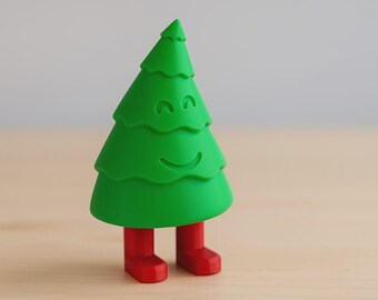 Puede incluir: Una caprichosa figura de árbol de Navidad verde con una cara sonriente y botas rojas. El árbol tiene un diseño en capas y una parte superior puntiaguda. Una decoración festiva.