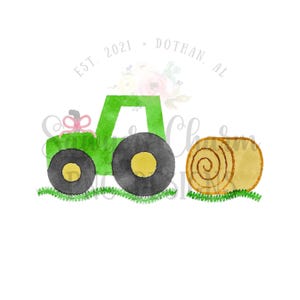 Puede incluir: Un tractor de juguete verde con un lazo rosa en la parte trasera, tirando de una paca de heno marrón. El tractor tiene ruedas negras con centros amarillos. El texto "EST. 2021 - DOTHAN, AL" está por encima del tractor.