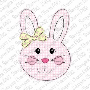 Op de afbeelding: Een roze en wit geblokt konijn met zwarte ogen en een gele strik met roze bloemen. Het konijn heeft een gestikte omtrek.