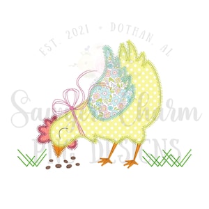 May include: A yellow chick with a pink bow and a floral patterned wing is pecking at brown seeds on the ground. The chick is surrounded by green grass. The text "EST. 2021 - DOTHAN, AL" is in a circle above the chick.