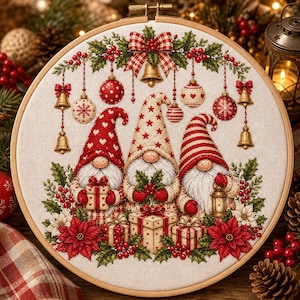 May include: A circular embroidery hoop containing a cross-stitch pattern of three gnomes wearing festive hats. The gnomes are surrounded by hanging ornaments, bells, poinsettia flowers, and wrapped gift boxes in red, white, and gold colors.