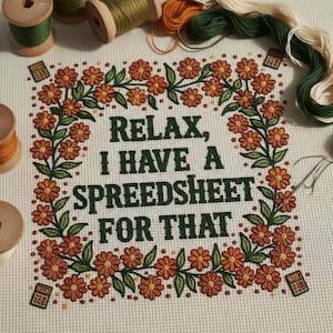 May include: Cross-stitch embroidery with the text "Relax, I have a spreadsheet for that" framed by orange flowers and green leaves. The image includes spools of thread and a needle. The design is on a cream-colored fabric.