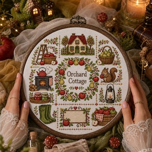 May include: A round wooden embroidery hoop containing a cross-stitch pattern titled Orchard Cottage. The design features a central fruit wreath, a house, a squirrel, a stove, a lantern, baskets of apples and pears, and green boots.