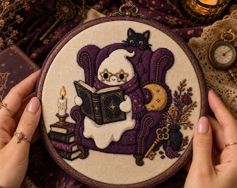 Op de afbeelding: Een ronde borduurring met een kruissteekontwerp van een witte geest met een ster-vormige bril en een paarse sjaal, zittend in een paarse gecapitonneerde fauteuil terwijl deze een boek leest. Een zwarte kat en een gouden sleutel zijn zichtbaar.