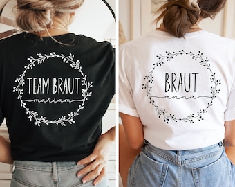 May include: Two white t-shirts with black text and floral wreaths. One shirt says "Team Braut mariam" and the other says "Braut anna".